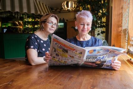 Санкт-Петербург. Женщины пенсионного возраста  читают газету `Комсомольская правда`в кафе.