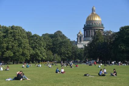 Санкт-Петербург. Молодые люди отдыхают на газоне  у Исаакиевского собора.