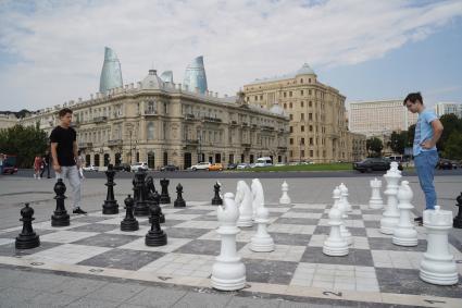 Азербайджан. Баку.  Молодые люди играют в шахматы на одной из улиц города.