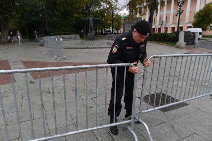 Москва. Полицейский устанавливает  заграждение на  Страстном бульваре.