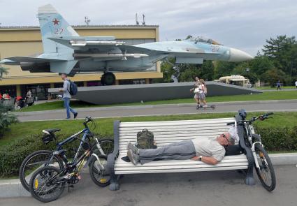 Москва.  Мужчина отдыхает на скамейке у павильона  `Космос`.