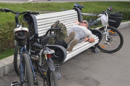 Москва. Мужчина отдыхает на скамейке.