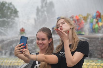 Москва. Девушки фотографируются у фонтана `Каменный цветок`.