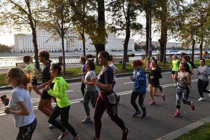 Москва. Молодые люди  бегут по Пушкинской набережной.