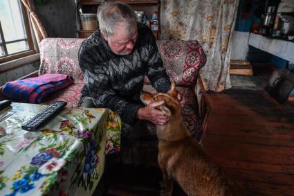 Архангельская область, деревня Монастырка.  Местный житель у себя в доме.