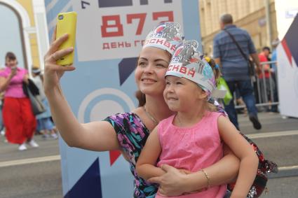 Москва. Женщина с ребенком во время праздничных мероприятий в честь Дня города на Тверской улице.