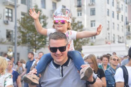 Москва. Мужчина с ребенком во время праздничных мероприятий в честь Дня города на Тверской улице.