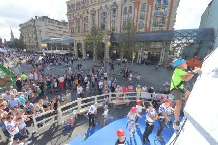 Москва. Мальчик на скалолазной стенке во время праздничных мероприятий в честь Дня города на Тверской улице.