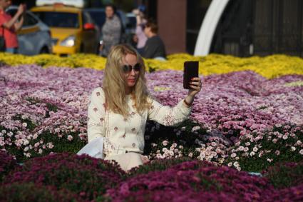 Москва.  Туристы фотографируют цветочные композиции, созданные   в рамках фестиваля `Цветочный джем` на Манежной площади.