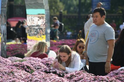 Москва.  Туристы фотографируют цветочные композиции, созданные   в рамках фестиваля `Цветочный джем` на Манежной площади.