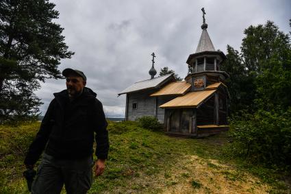 Республика Карелия, Пегрема. Корреспондент `Комсомольской правды` Дмитрий Стешин  у деревянной часовни 18 в. Варлаама Хутынского в  заброшенной деревне.