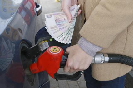Барнаул. Девушка заправляет автомобиль на автозаправочной станции `Роснефть`.