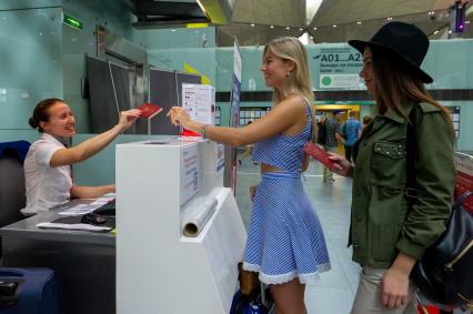 Санкт-Петербург. Девушки у стойки регистрации на рейс в  международном аэропорту`Пулково`.