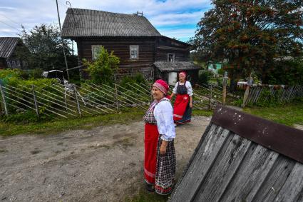 Республика Карелия, деревня Корза. Местные жительницы в национальных карельских костюмахь  на деревенской  улице.