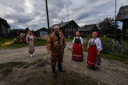 Республика Карелия, деревня Корза.  Корреспондент `Комсомольской правды` Дмитрий Стешин среди местных жительниц в национальных карельских костюмах.