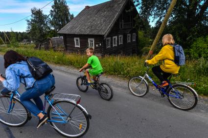 Республика Карелия, деревня Корза. Велосипедисты на деревенской улице.