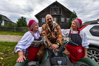 Республика Карелия, деревня Корза.  Корреспондент `Комсомольской правды` Дмитрий Стешин среди местных жительниц в национальных карельских костюмах.