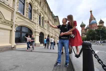 Москва. Молодые люди фотографируются на Красной площади.