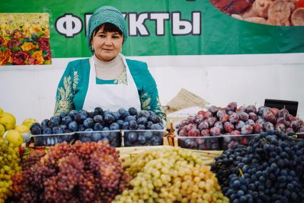 Самара. Женщина продает виноград на  Гастрономическом фестивале.