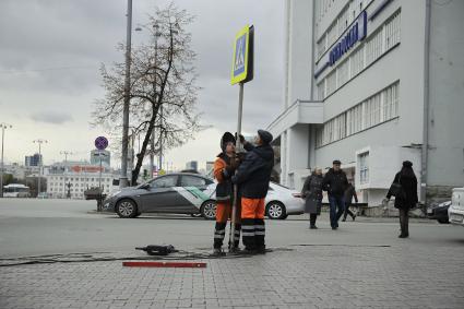 Екатеринбург. Рабочий устанавливает дорожный знак у пешеходного перехода