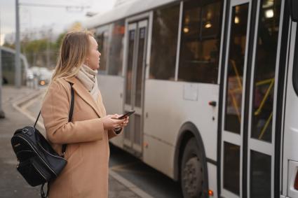 Самара. Девушка с мобильным телефоном на автобусной остановке.