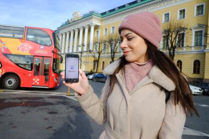 Санкт-Петербург. Девушка демонстрирует приложение `Яндекс.Транспорт` в мобильном телефоне.