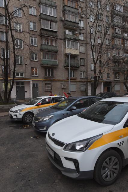 Москва.  Автомобили сервиса `Яндекс.Такси` во дворе жилого дома.