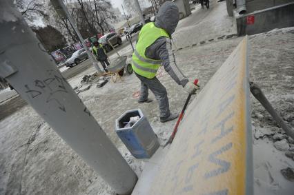 Екатеринбург. Рабочие в снег укладывают тротуарную гранитную плитку