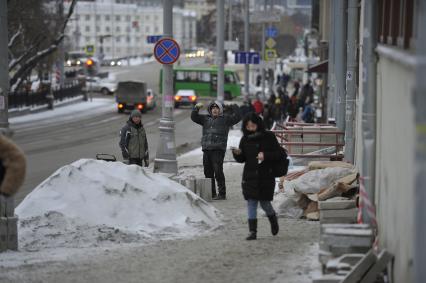 Екатеринбург. Рабочие в снег укладывают тротуарную гранитную плитку