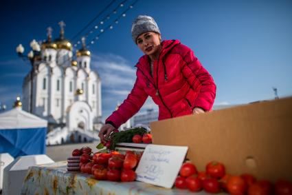 Магадан. Женщина торгует помидорами у Свято-Троицкого кафедрального собора.