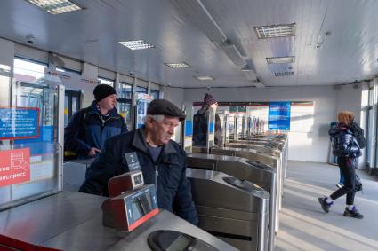 Москва. Пассажиры проходят через турникеты к поездам Московского центрального диаметра.