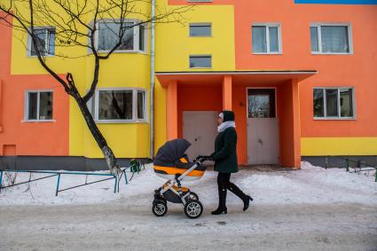 Магаданская область,  Усть-Омчуг. Женщина с коляской на улице города .