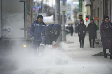 Екатеринбург. Рабочие укладывают тротуарную гранитную плитку в морозы