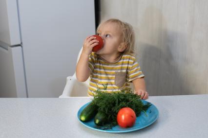 Самара.  Ребенок ест помидор.