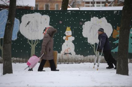 Екатеринбург. Горожане на фоне забора с нарисованым снеговиком