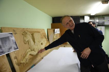 Москва. Мастер во  время реставрации декоративных элементов  кинотеатра `Художественный`.