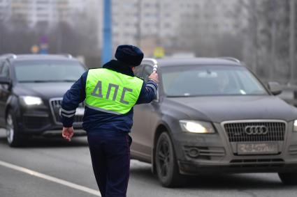 Москва.   Сотрудник ДПС во время дежурства на дороге.