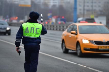 Москва.   Сотрудник ДПС во время дежурства на дороге.