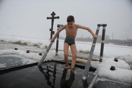 Екатеринбург. Ребенок окунается в проруби во время крещенских купаний на Верх-Исетском пруду при температуре -3 градуса