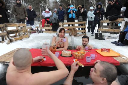 Екатеринбург. Участники федерации зимнего плавания Свердловской области устроили импровизированое чаепитие в проруби во время крещенских купаний на озере Шарташ при температуре -3 градуса