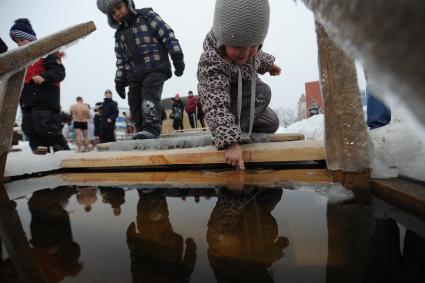 Екатеринбург. Ребенок пробует температуру воды в проруби во время крещенских купаний на Верх-Исетском пруду при температуре -3 градуса