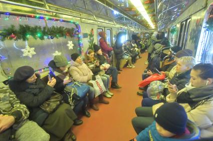 Москва.  Пассажиры в вагоне новогоднего поезда Московского метрополитена.