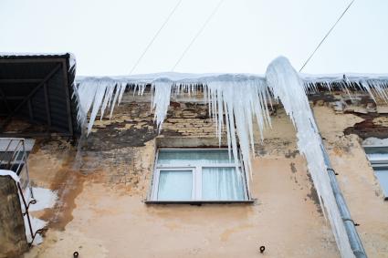 Пермь.   Сосульки на карнизе дома.