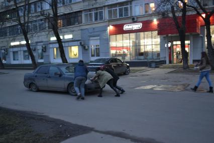 Москва. Девушки толкают автомобиль.