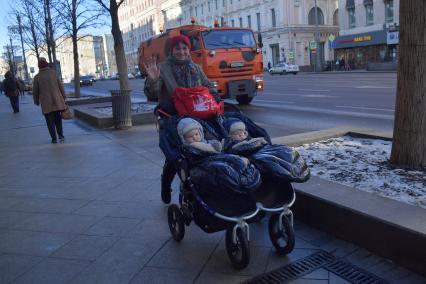 Москва. Женщина везет в коляске двойняшек  по Тверской улице.