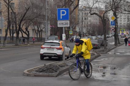 Москва.  Сотрудник сервиса доставки еды `Яндекс.Еда` на одной из улиц города.