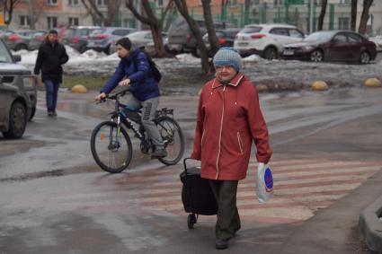 Москва.  Пожилая женщина с тележкой.