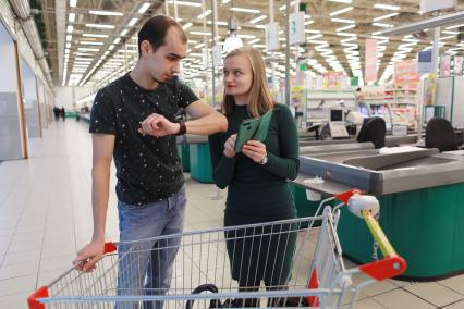 Красноярск. Молодые люди в магазине с продуктовой тележкой.