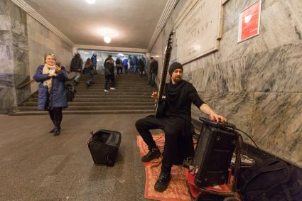 Москва.  Мужчина  играет на ситаре на станции метро `Арбатская`.