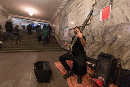 Москва.  Мужчина  играет на ситаре на станции метро `Арбатская`.